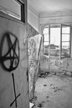 Satanic symbols graffiti on the door of an abandoned house. Black and white.
