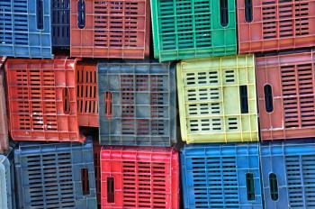 Colorful plastic crates background. Stacked fruit packing containers.