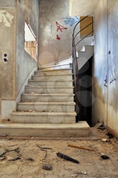 Vintage staircase and dirty floor in abandoned building interior.