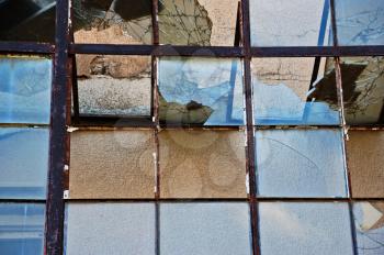 Smashed glass and rusty metal background. Vandalized attrium of derelict building.