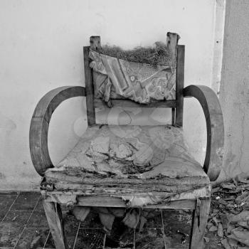 Torn armchair and pile of broken glass. Black and white.