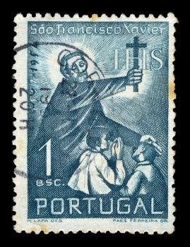PORTUGAL - CIRCA 1952. Vintage canceled postage stamp with illustration of Saint Francis Xavier holding a cross and blessing two children, circa 1952.