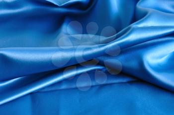 Blue fabric texture. Folded silk textile abstract background.