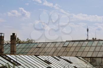 Greenhouse glass roof and cloudy sky. Abstract background.
