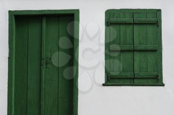 Wooden door and window shutter. Old house white wall background texture.