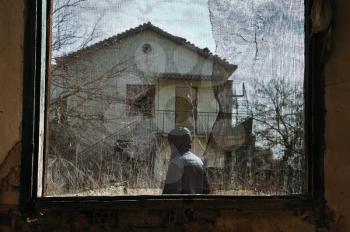Old window with net abstract and man in the garden of an abandoned house.
