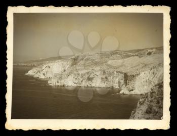 Old photograph of steep sea cliffs rocky headlands. Vintage style digital composite.