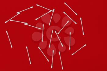 Ear buds white cotton swabs on red background.