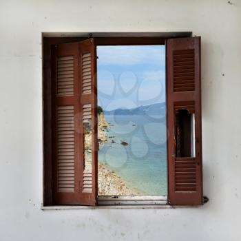 View of beach landscape through broken window frame. Wooden shutter abstract.