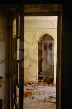 Doors and broken floor tiles in abandoned decayed house interior.