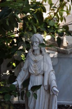 Jesus Christ marble funerary statue among leaves.