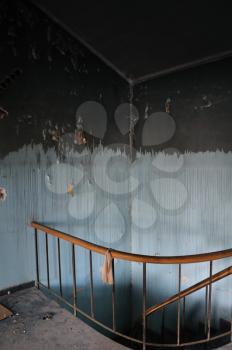 Paint stained wall and vintage staircase in abandoned house interior.