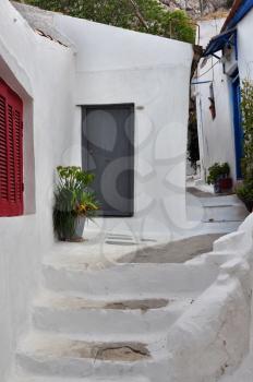 Steps, white painted narrow street and small houses in the traditional Anafiotika neighborhood of Plaka, Athens Greece.