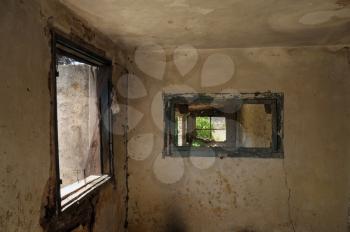 Windows and weathered wall in abandoned interior.