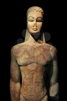 Kouros of the sacred gate ancient greek statue of male figure on black background. Kerameikos museum, Athens Greece.