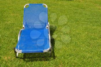 Lawn chair on green grass background. Garden furniture.