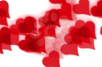 Red hearts bokeh pattern on white background. Love and romance abstract.