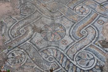 Ancient roman floor mosaic with geometric shapes motif and floral pattern. Abstract background.