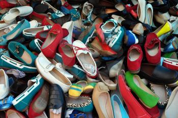 Shoes for sale at street market. Pile of assorted footwear abstract background.