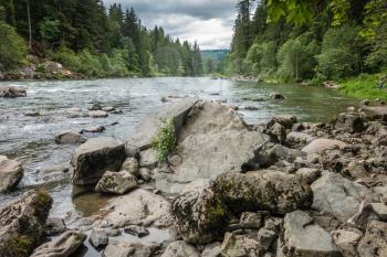 A view of the Snoqualmie River with rocks in the foreground.
