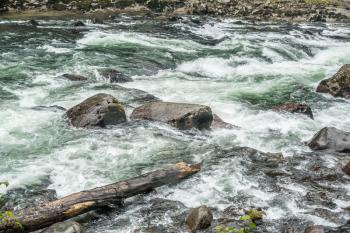 White water rushes past boulders on the Snoqualmie River in Washington State.