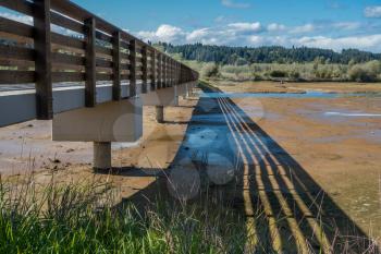 A walking bridge spans mud flats and wetlands at The Theler Wetlands in Belfair, Washington.