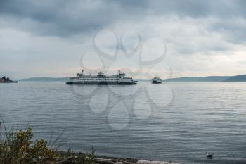 One ferry in coming and one is going in West Seattle, Washington on an overcast day.