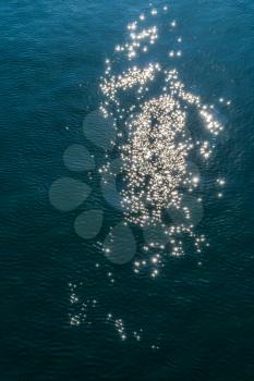 Abstract spots are created by light reflecting on ocean water.