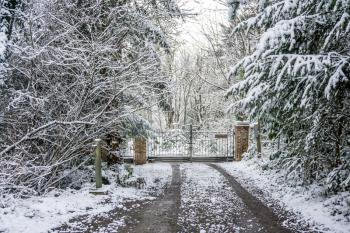 A view of a private gate that is surrounded by snow.