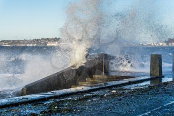 Waves crash on the waterfront at Alki Beach in West Seattle, Washington.