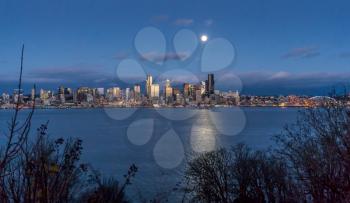 A bright full moon shines over the Seattle skyline.