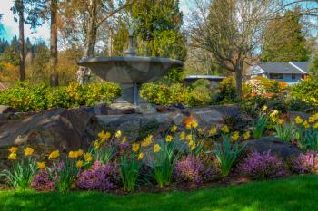 A veiw of Spring flowers and a cement fountain in Normandy Park, Washington. HDR image.