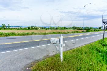 A view of a road, a field and Mount Rainier in Kent, Washington.