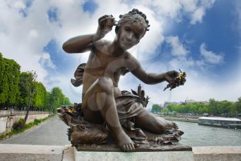 sculpture of a child on the Pont Alexandre III bridge in Paris holding padlocks. france