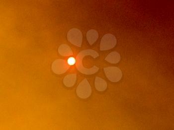 Orange sun in smoky sky of wildfire