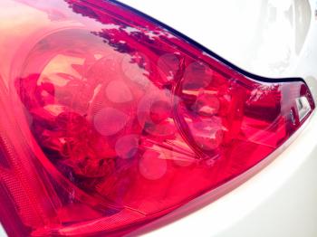 Left rear red brake light close-up shiny smooth reflections