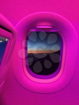 Airplane cabin window with map and sunset vertical