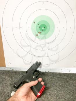 Fireams training pistol and bullet holes with hand
