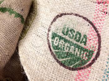 Burlap coffee bean bags on floor with organic imported coffee