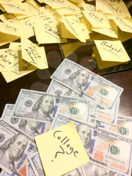 many post it notes on table with pile of american cash vertical