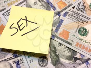 American cash money and yellow post it note with text Sex in black color aerial view
