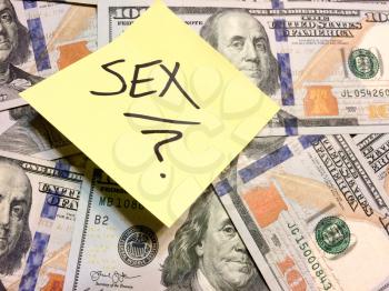 American cash money and yellow post it note with text Sex with question mark in black color aerial view