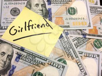 American cash money and yellow post it note with text Girlfriend in black color aerial view