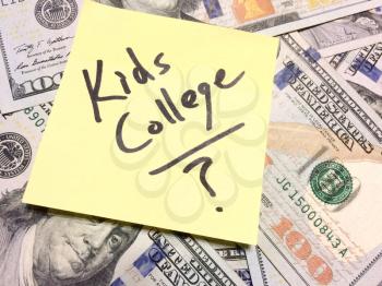 American cash money and yellow post it note with text Kids College with question mark in black color aerial view