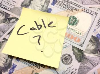 American cash money and yellow paper note with text Cable with question mark in black color aerial view