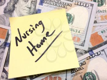 American cash money and yellow paper note with text Nursing Home in black color aerial view