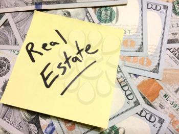 American cash money and yellow sticky note with text Real Estate in black color aerial view
