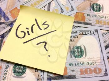 American cash money and yellow sticky note with text Girls with question mark in black color aerial view