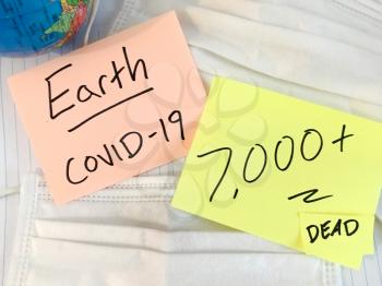 Coronavirus COVID-19 infection medical cases and deaths on Earth. China COVID respiratory disease influenza virus statistics hand written on surgical mask and earth globe background