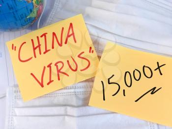 China virus Coronavirus COVID-19 infection medical cases and deaths . COVID respiratory disease influenza statistics hand written on surgical mask and earth globe background